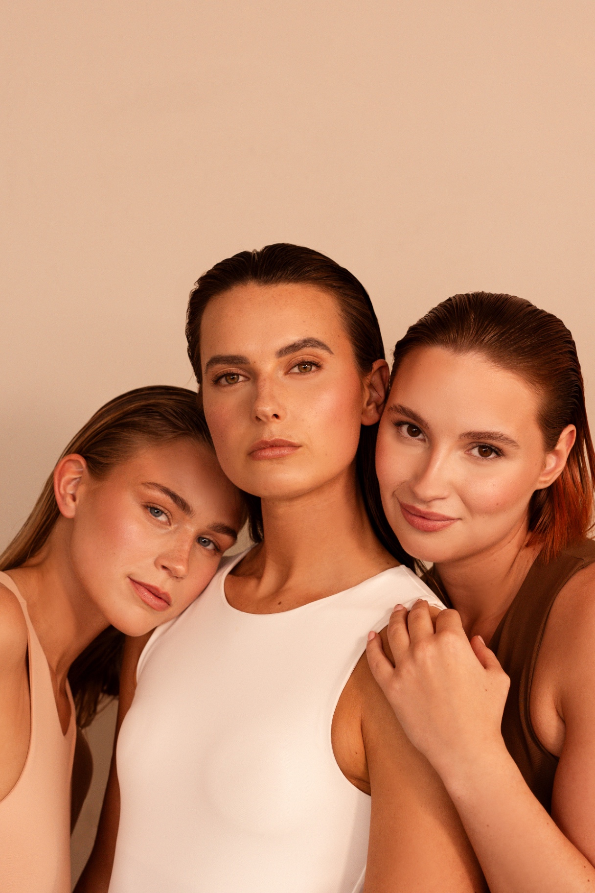 Close-up van drie gezichten met natuurlijke spray tan glow