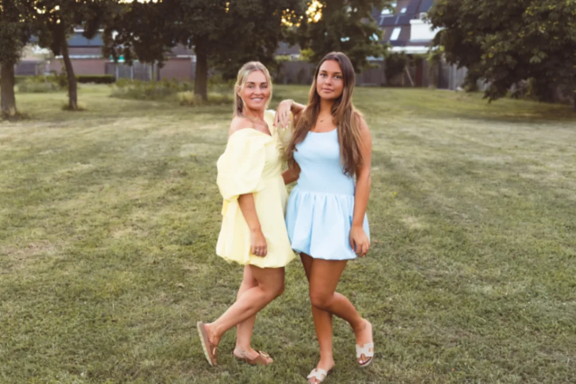 Ghislaine en Esme, oprichters van Studio Eslaine spray tan studio in Nijmegen, samen buiten in zomerse jurken met een natuurlijke, egale glow